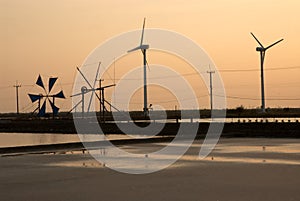 Sunset at ancient and new wind mill use for move the sea water i