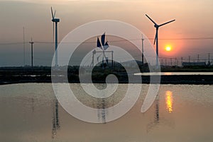 Sunset at ancient and new wind mill use for move the sea water i