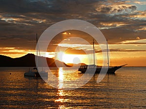 Sunset in ArmaÃ§Ã£o beach in BÃºzios, Rio de Janeiro, showing two sailboats