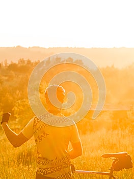 Sunset. Athlete with a bicycle near the forest. Beautifu frontal