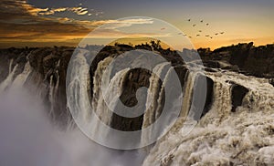 Sunset at the Augrabies water falls in South Africa. Load waters and full color skies.