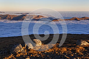 Sunset in the autumn alpine mountains, above the clouds, sea of clouds, Carpathians