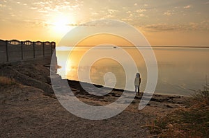 Sunset on the Azov Sea, girl on the shore