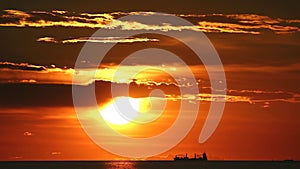 sunset back on dark cloud on sea and silhouette cargo ship in summer