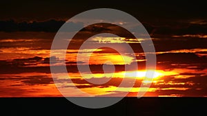 Sunset back on red orange cloud and silhouette cargo ship passing on sea