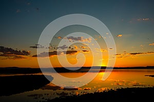 Sunset background photo. Sunrays and partly cloudy sky over the lake