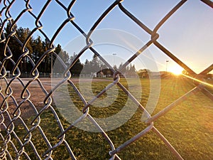 sunset baseball field chain link fence closeup afternoon sports ballpark park sport fields athletics fencing