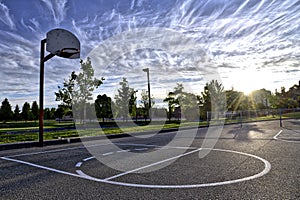 Sunset on a basketball court with the clear blue sky background