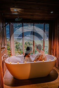 Sunset in bathtub in the bathroom during vacation in Thailand watching sunset over the ocean and moutnains Phangnga Bay photo