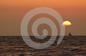 Sunset Beach Background. waves of the sea in the rays of the evening sunset. the sun goes below the horizon