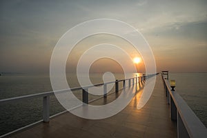 Sunset on beach and bridge silhouette