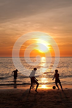 Sunset beach with Kids playing football