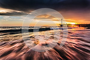 Waves at sunset on meditarranean sea photo