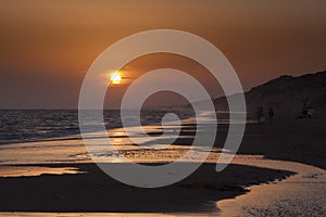 Sunset on the beach, people silhouette in Mazagon, Huelva photo