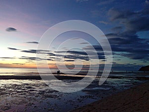 A sunset on the beach people walking