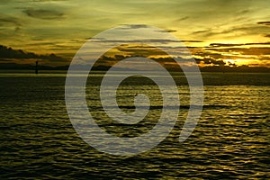 Sunset at the beach by the pier on a cloudy romantic day