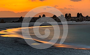 sunset by the beach with reflection of the last golden hour sunshine on the ocean wave