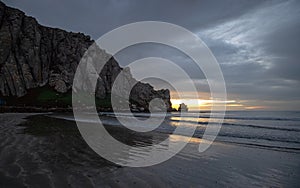 Sunset beach reflections at Morro Rock on the central coast of California at Morro Bay California USA