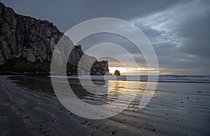 Sunset beach reflections at Morro Rock on the central coast of California at Morro Bay California USA