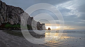 Sunset beach reflections at Morro Rock on the central coast of California at Morro Bay California USA