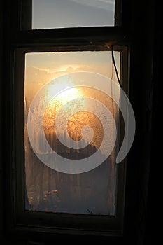 Sunset beams through the frozen glass window