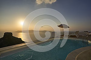 Sunset at a beautiful infinity pool in Santorini, Greece