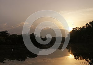 Sunset behind clouds with reflection in Sanjay lake at Delhi