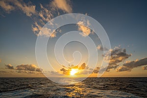 Sunset behind a cruising cruise ship at sea