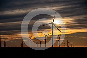 Sunset behind a field of wind turbines