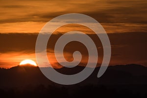Sunset behind mountain and cloud