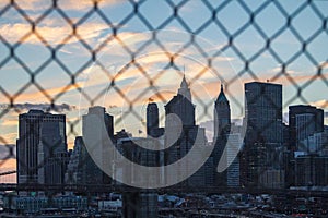 Sunset behind New York City Through Fence