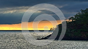 Sunset behind a rocky islet