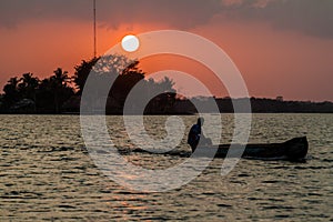 Sunset behind Santa Barbara islet with a boat crossing Peten Itza lake near Flores city, Guatema