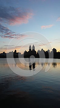 Sunset behind Upper West Side Buildings Seen from Jacqueline Kennedy Onassis Reservoir in Central Park in Manhattan, New York, NY.