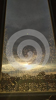 Sunset behind windowglass with raindrops.