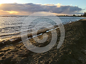 Sunset at Black and White Sand Beach with Reef in Winter in Kekaha on Kauai Island, Hawaii - Niihau Island in Horizon.