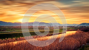 Sunset and blurred clouds illuminate the fertile fields