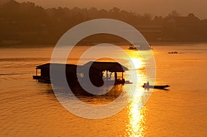Sunset and boat with floating house