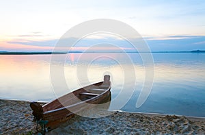 Sunset with boat near the summer lake shore