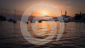 Sunset with boats and the old town of Rovinj in Croatia