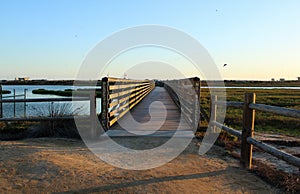 Sunset at bolsa chica wetlands through a wooden bridge photo