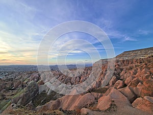 The sunset brightens the red and rose limestone rocks in the Red Valley of Cappadocia, Turkey