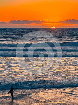 sunset at a california beach with surfer