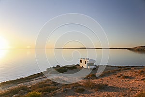 Sunset with camper at ocean shore 1