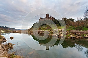 Sunset at Castle Almourol, river Tagus in Portugal. Amazing landscape at sunset with the castle walls under red cloud sky. Beautif
