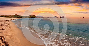Sunset on Cea beach with Red Rocks Gli Scogli Rossi - Faraglioni on background.