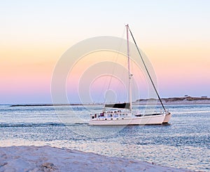 Sunset charter sail at Ponce Inlet jetty with New Smyrna Beach in the background photo