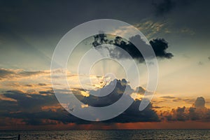 Sunset with clouds, light rays and other atmospheric effect. Dramatic cloudy skyline