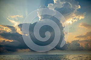 Sunset with clouds, light rays and other atmospheric effect. Dramatic cloudy skyline