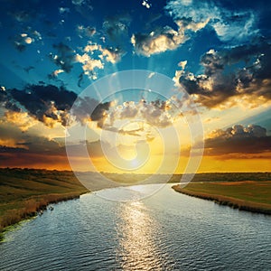 Sunset with clouds, light rays over river